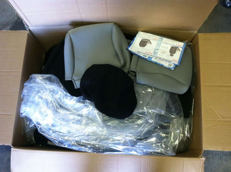Gray and black seat covers in a box with instructions