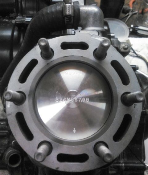 1900 Honda Big Red - Close-up view of an engine cylinder and piston, revealing stamped part numbers.