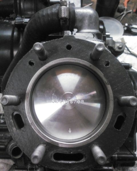 1900 Honda Big Red - Close-up of an engine cylinder and piston, with visible part identification numbers.