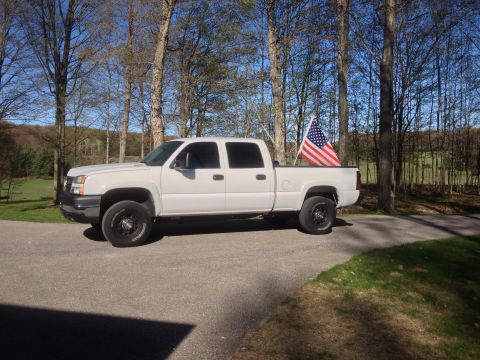 2006 Chevrolet Silverado 2500 - White 2006 Chevrolet Silverado 2500 pickup truck parked outdoors with an American flag in the bed.