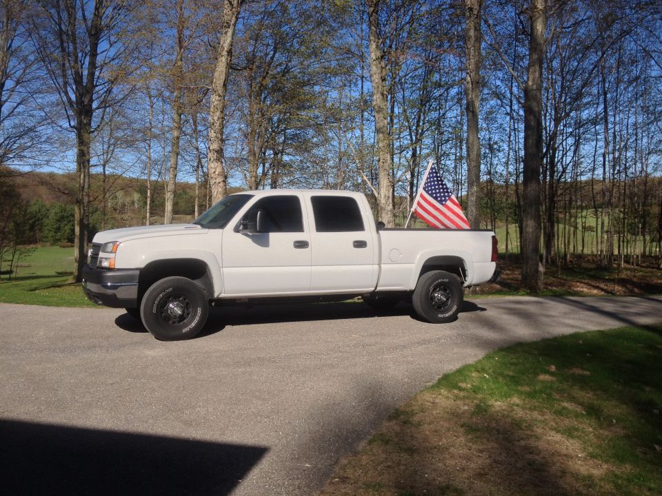 2006 Chevrolet Silverado 2500 pickup truck, side view, with an American flag in the bed