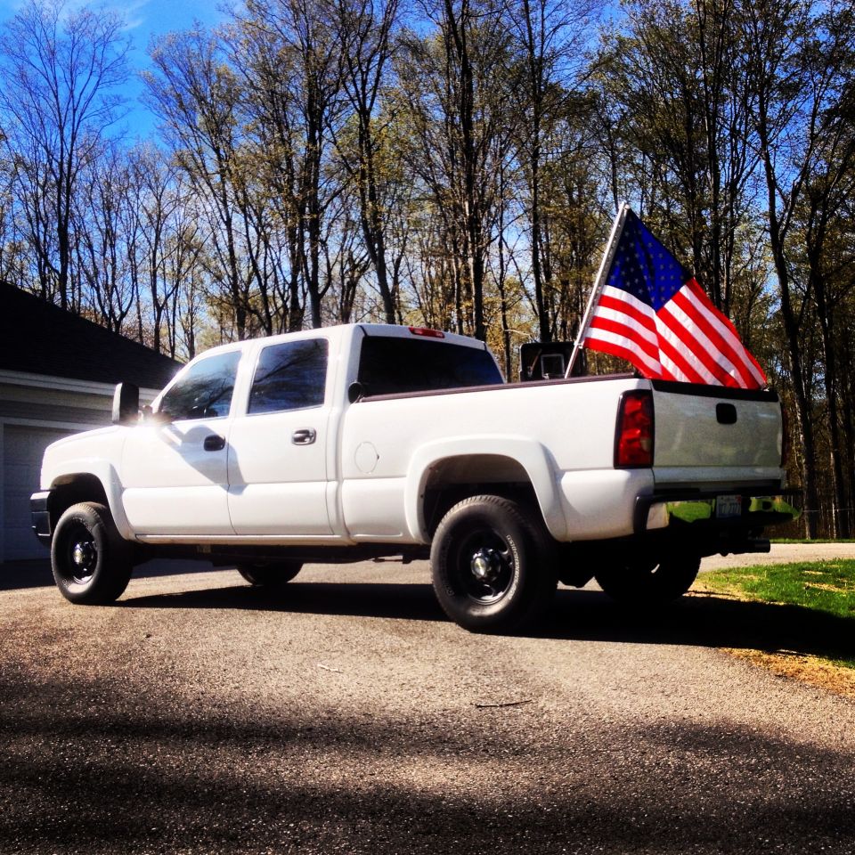 White 2006 Chevrolet Silverado 2500 pickup truck, side view, with American flag