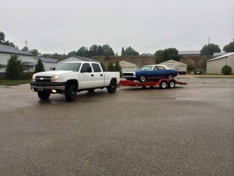 2006 Chevrolet Silverado 2500 - White 2006 Chevrolet Silverado 2500 hauling a blue convertible on a trailer.
