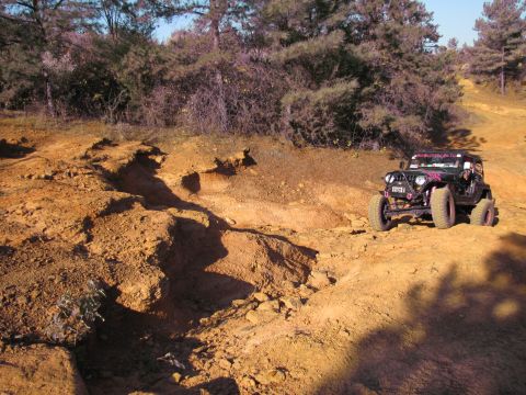 1995 Ford Bronco - Jeep Wrangler navigating a challenging off-road course with steep inclines.