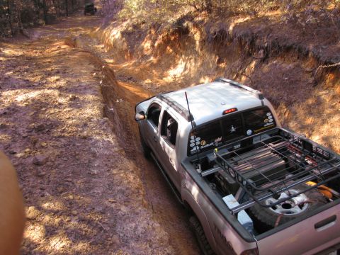 1995 Ford Bronco - A pickup truck navigates a challenging off-road trail with another vehicle ahead.