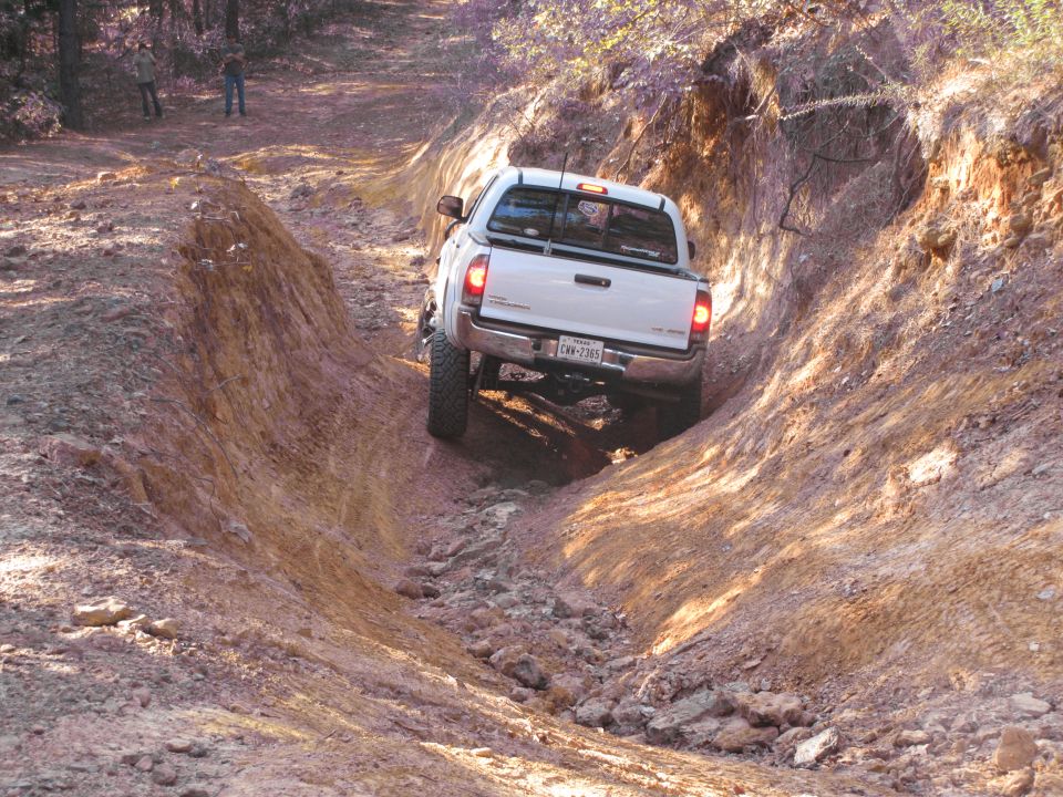 White pickup truck navigating a steep, rocky off-road trail. License plate reads 'CRV-2365'