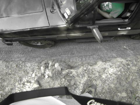 1995 Ford Bronco - A black Ford Bronco is seen from a high angle, with the driver's door open and a person inside wearing a green shirt.