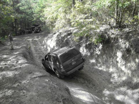 1995 Ford Bronco - Multiple vehicles on an off-road trail, one SUV is in the foreground.