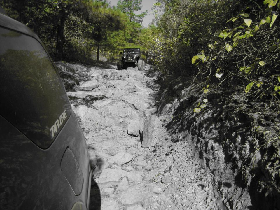 Black SUV side view on rocky trail with another Jeep ahead