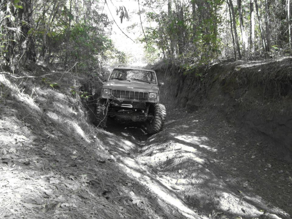 Jeep Cherokee XJ climbing a dirt trail, front winch visible