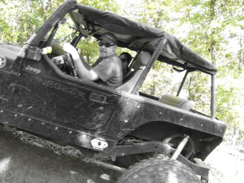 1995 Ford Bronco - A black Jeep Wrangler, identified as a Renegade, navigates an off-road trail with two occupants.