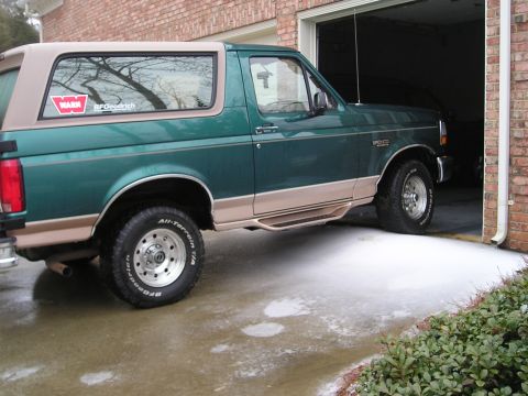 1996 Ford Bronco - 1996 Ford Bronco with tan top, partially in garage with snow on the ground.