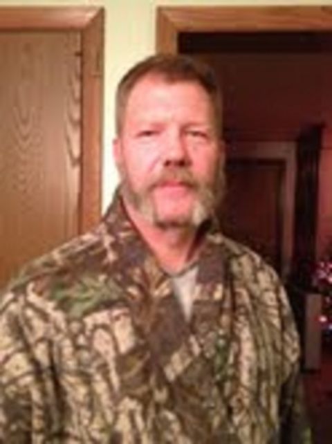 1979 Ford F-150 - A man with a beard and goatee wears a camouflage jacket indoors, with wooden doors visible behind him.