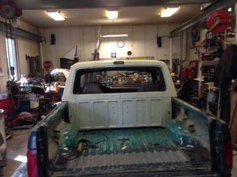1993 Ford Bronco - Interior and bed of a 1993 Ford Bronco, parked inside a workshop.