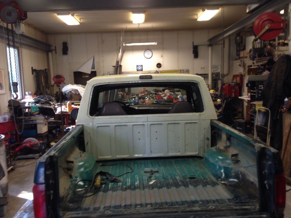 1993 Ford Bronco interior and bed, viewed from rear inside a garage