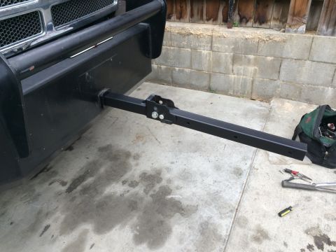 1997 Dodge 3500 - The front of a truck shows a heavy-duty hitch receiver attached to the bumper, with tools laid out on the concrete.