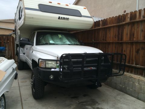 1997 Dodge 3500 - White 1997 Dodge 3500 truck fitted with a Lance camper shell and a heavy-duty brush guard.