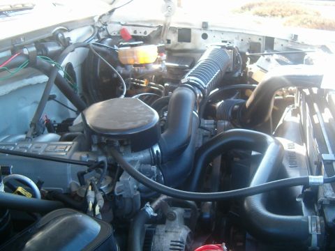 1996 Ford Bronco - Engine bay of a 1996 Ford Bronco showing various components and hoses.