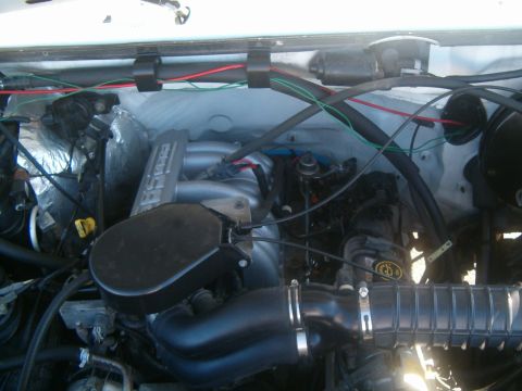 1996 Ford Bronco - The engine bay of a 1996 Ford Bronco is visible, with various hoses and wiring present.