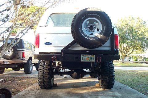 1995 Ford Bronco - Rear view of a modified 1995 Ford Bronco with large tires and a spare tire mounted externally.