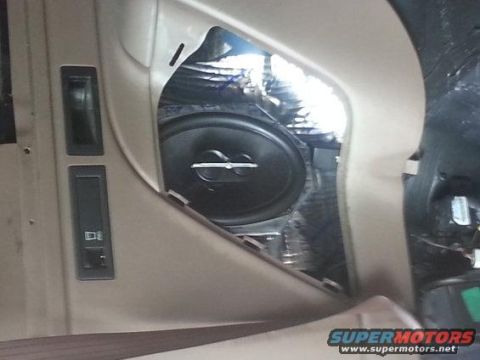 1994 Ford Bronco - Photograph of a vehicle door panel showing an installed speaker, window controls, and foil insulation.