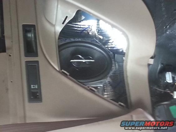 Car door panel with installed speaker and window controls