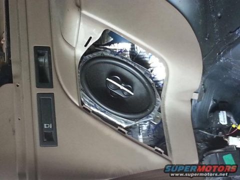 1994 Ford Bronco - Photograph of a vehicle door panel showing an installed coaxial speaker and window switch.