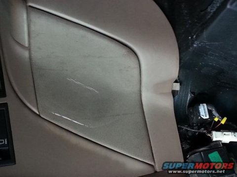 1994 Ford Bronco - Photograph of a tan vehicle interior trim panel with scuff marks, not a technical document.