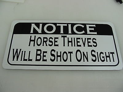 1974 Ford Bronco - A silver and black rectangular sign reads "NOTICE HORSE THIEVES WILL BE SHOT ON SIGHT". The sign is mounted on a white surface.