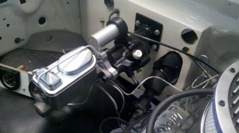 1982 Ford Bronco - The image shows a close-up view of the engine bay of a vehicle, focusing on the brake master cylinder and power brake booster assembly. The…