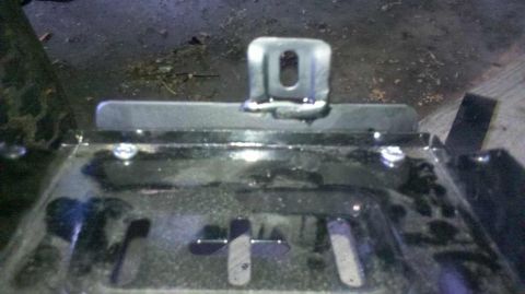 1982 Ford Bronco - A close-up view of a metal bracket welded to a black surface, likely part of a vehicle's undercarriage or frame. The bracket has a U-shape…