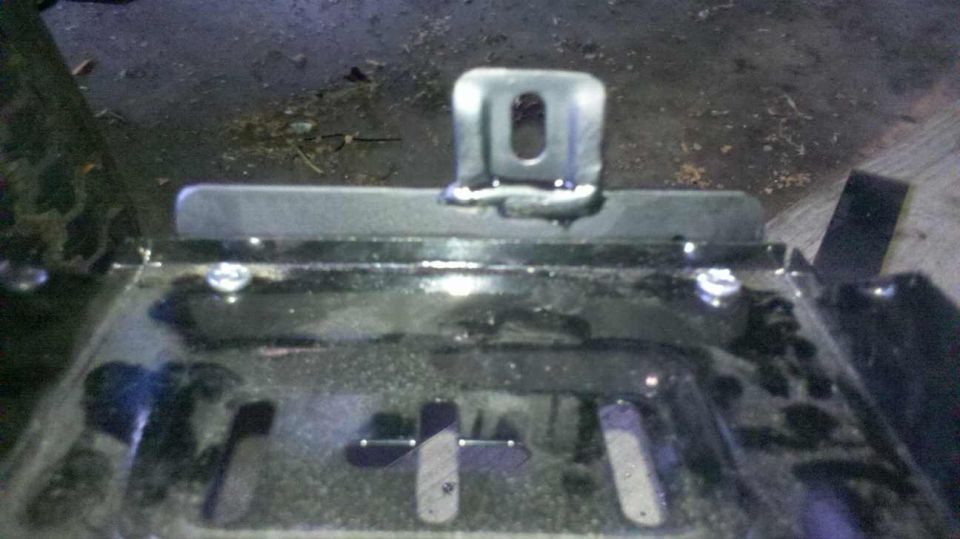 Close-up of a welded metal bracket with a hole.