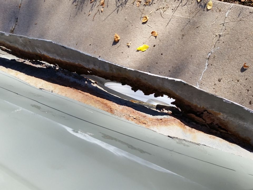 Rusted metal gutter or flashing with visible damage.