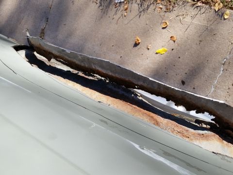 1988 Ford Bronco - The image shows a heavily rusted and damaged metal edge, likely a gutter or trim piece, on a vehicle. The metal is peeling and exposes sign…