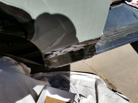 1988 Ford Bronco - Light green vehicle body corner with rocker panel and lower door area sanded and patched for repair.