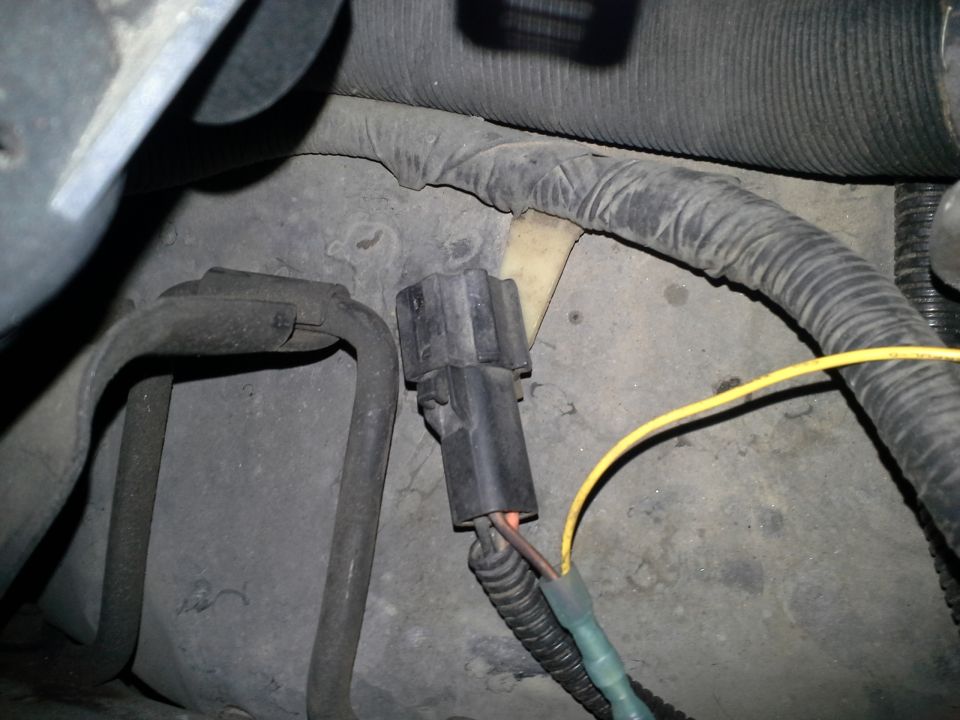 Black electrical connector with yellow wire in engine bay