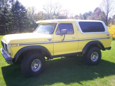 1979 Ford Bronco - Side view of a yellow 1979 Ford Bronco SUV with a white hardtop.