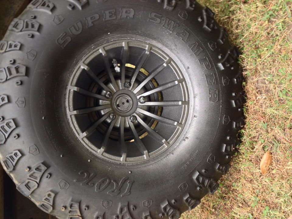 Tire with "SUPER SWAMPER IROK" text and a multi-spoke wheel