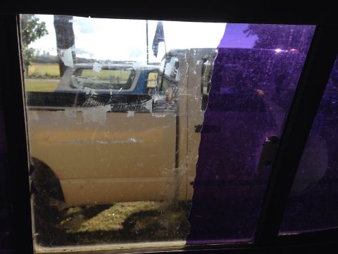 1979 Ford Bronco - A yellow pickup truck is seen through a damaged window, with another vehicle behind it.
