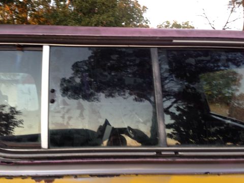 1979 Ford Bronco - Side view of a vintage vehicle, possibly from the late 1970s, with reflections in the glass.