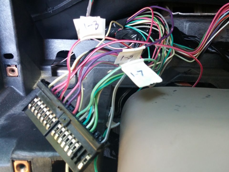 Photo of a tagged wiring harness and connector behind a dashboard