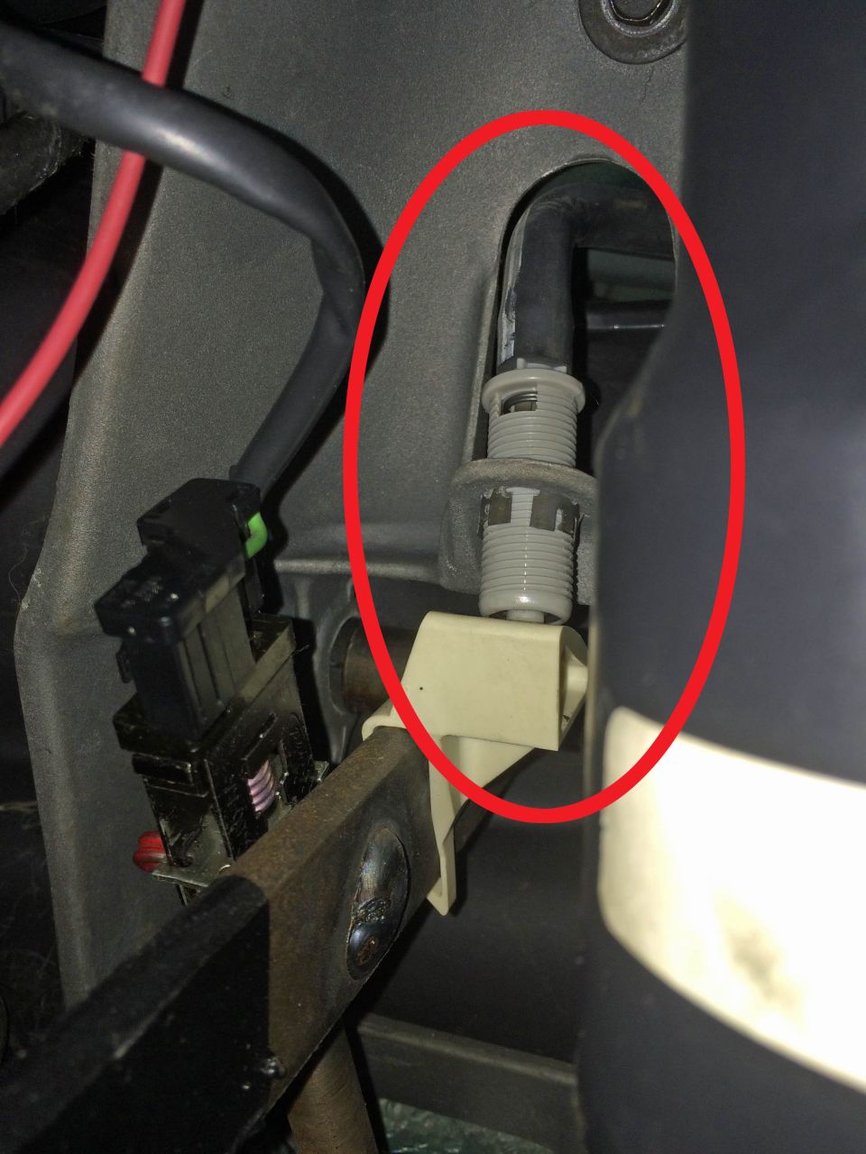 Close-up of a black cable with gray fitting in a vehicle interior.