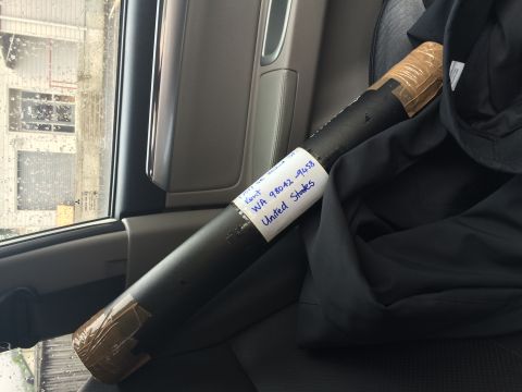 1993 Mazda MX-3 - A rolled item with a shipping label is secured inside a vehicle's passenger seat.