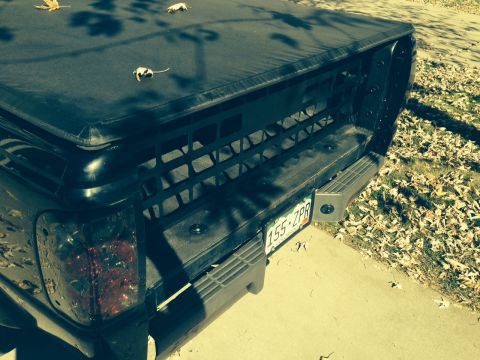 2001 Ford Ranger - The rear of a pickup truck is shown with a black tonneau cover and a license plate.