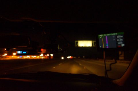 2003 Ford Taurus - View from inside a car at night, showing a GPS navigation screen and illuminated dashboard displays on the dashboard.