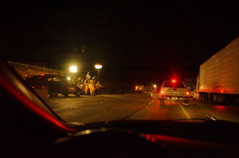 2003 Ford Taurus - Emergency responders are visible at a roadside incident on a dark highway at night.