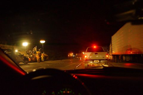 2003 Ford Taurus - Nighttime traffic jam with construction activity on the roadside, viewed from inside a vehicle.