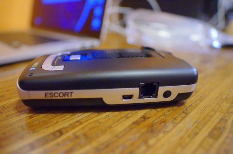 2003 Ford Taurus - A close-up view of an Escort radar detector, showing its ports and branding.