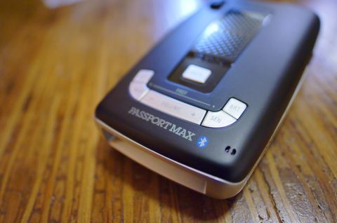 2003 Ford Taurus - Close-up of a black Passport Max radar detector with silver trim, resting on a wooden surface.