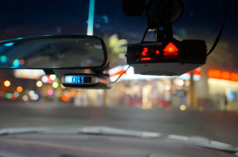 2003 Ford Taurus - A radar detector and rearview mirror are visible inside a vehicle at night, with blurred city lights in the background.